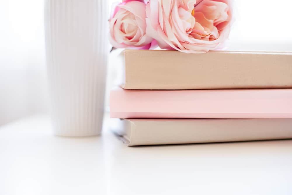 three journals on a table with flowers on top