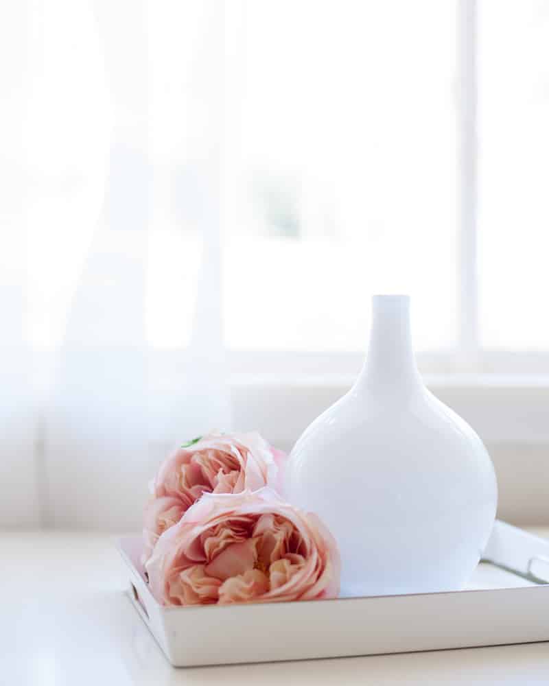 flowers and a vase in a tray on a table