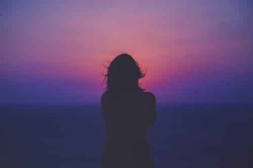 Woman in front of a purple sunset
