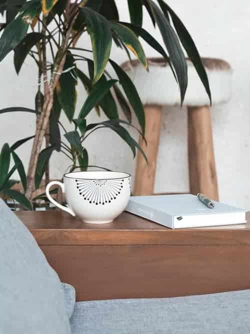 An affirmation journal, pen, and mug on a table