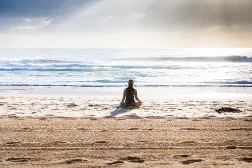 A person meditating on the beach