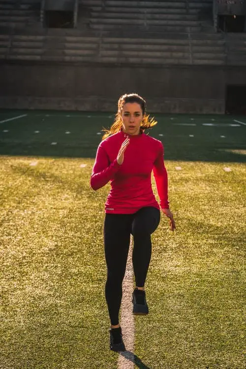 A woman warming up on a pitch