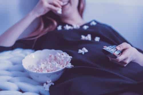 A woman eating a bowl of popcorn