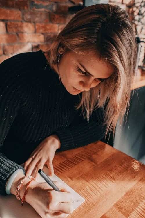 A woman writing on a pad of paper