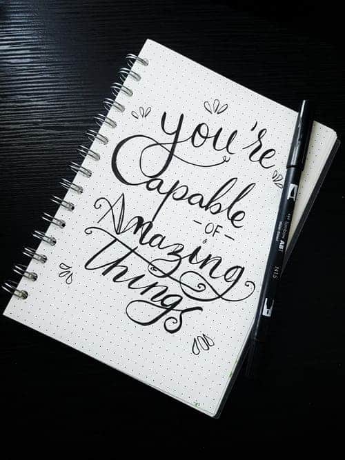 A journal that says "you're capable of amazing things" on the front