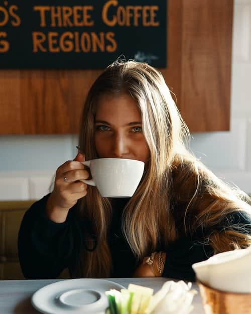 young woman drinking a coffee in a coffee shop