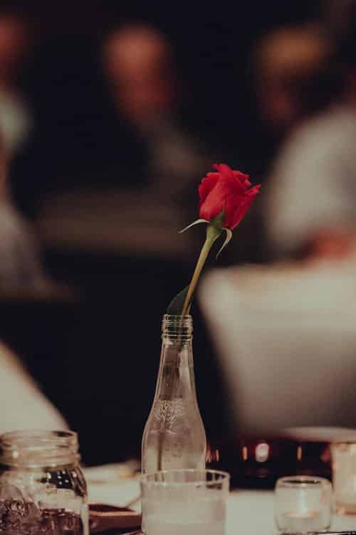 a rose in a bottle on a table