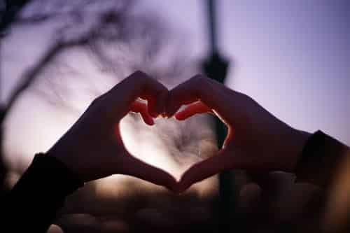 a person making a heart shape with their hands