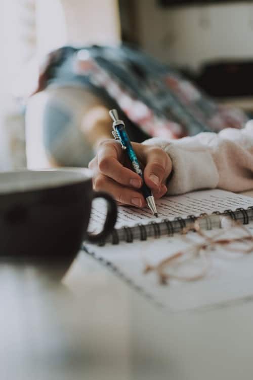 a hand writing in a notebook