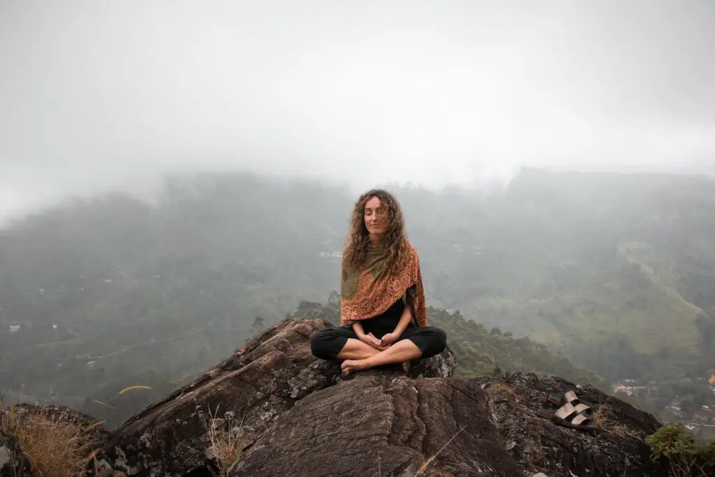 Woman meditating on a mountain top