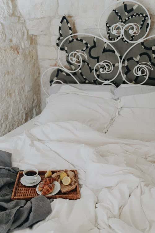 pastries and coffee on a tray on a bed