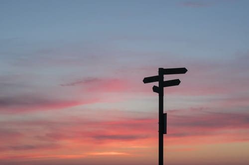 The silhouette of a road sign at dusk