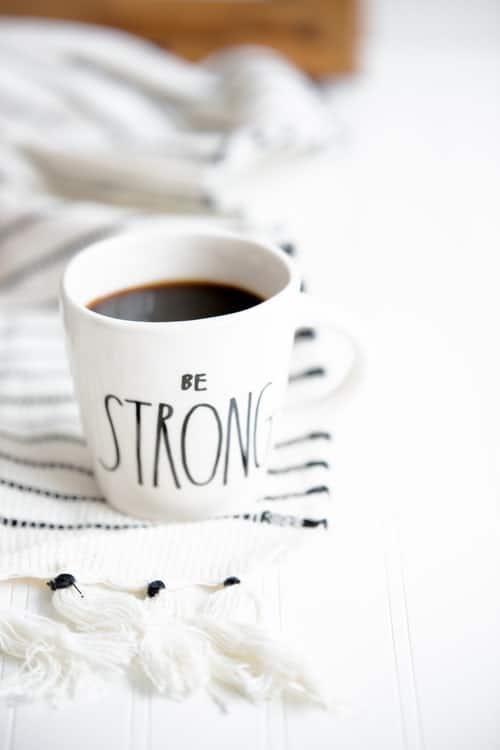 a mug of coffee with "be strong" on the side