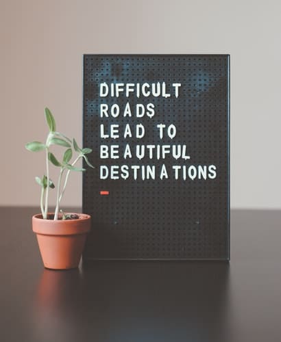 A message board that reads, "difficult roads lead to beautiful destinations"