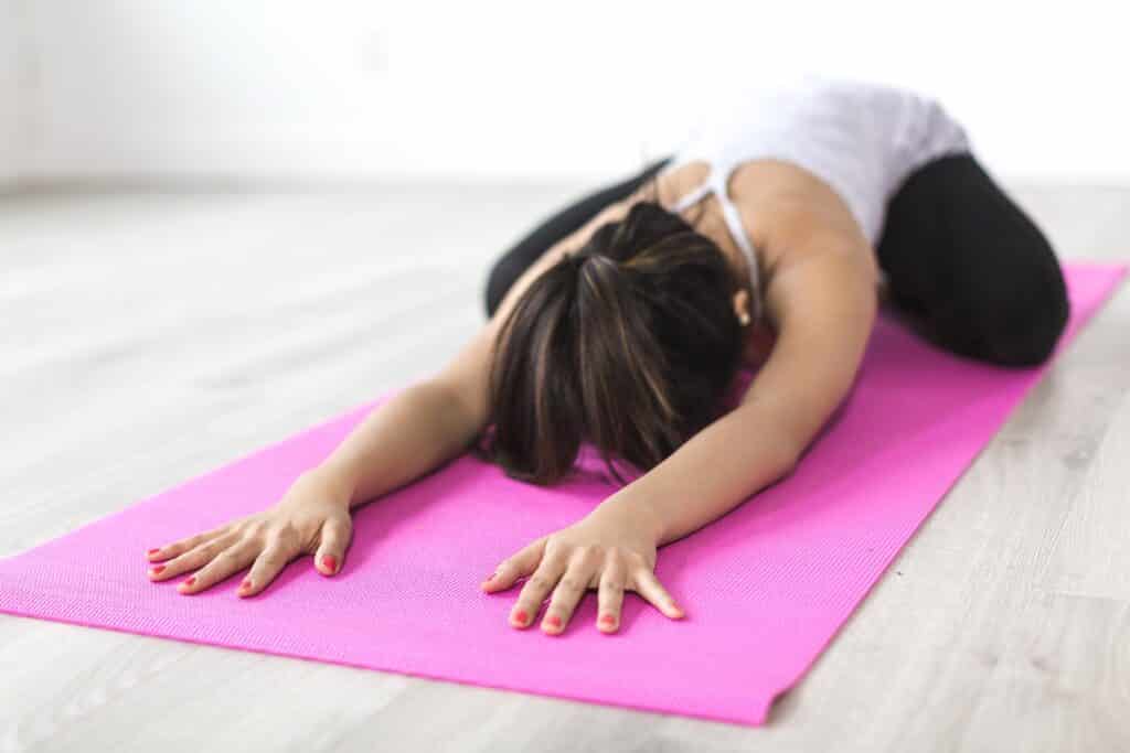 A woman performing a yoga stretch on a mat