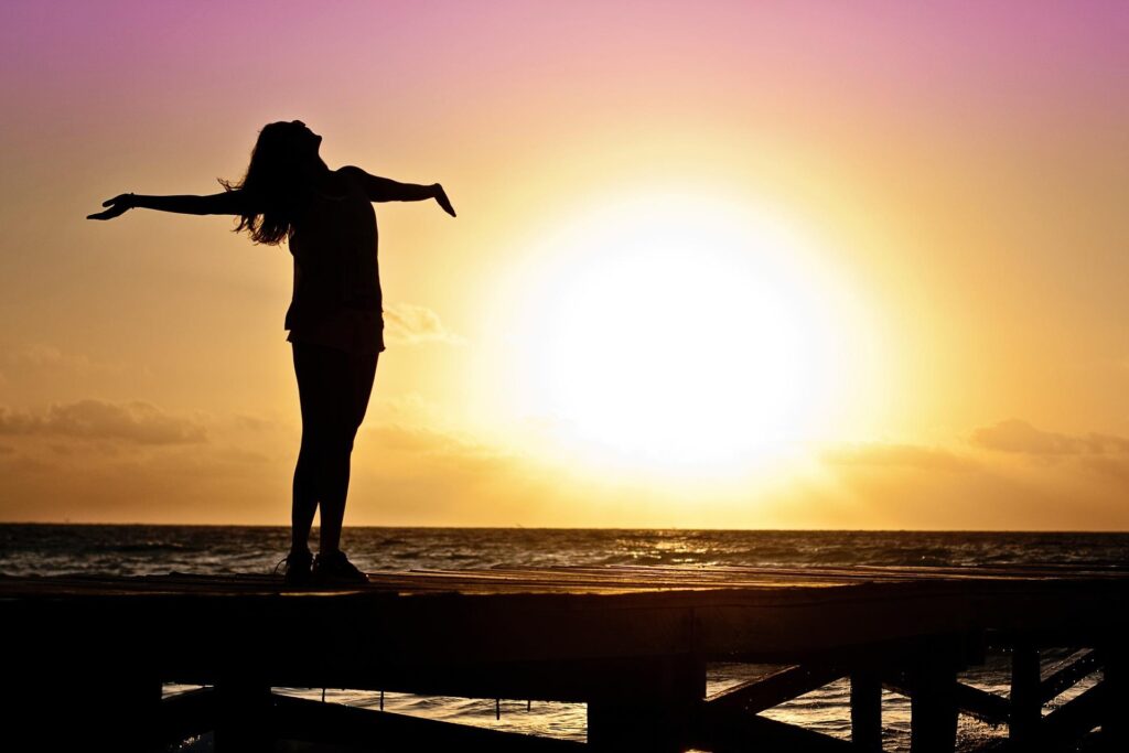 Silhouette of a woman at the beach during sunset.