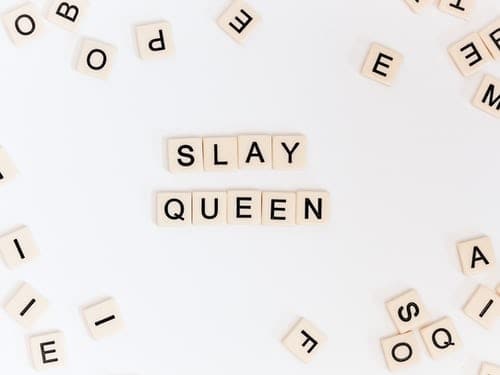 scrabble board letters spelling out "slay queen"