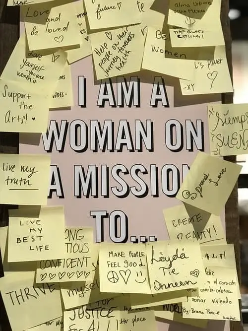 Affirmation art that says "I am a woman on a mission to..." with sticky notes finishing the affirmation stuck around it